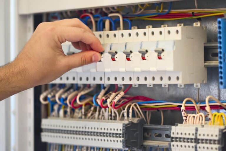 Male electrician working with equipment